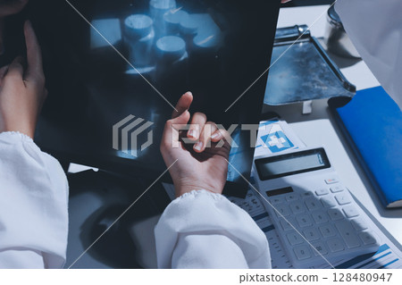 Male and female doctors are having a meeting in a hospital room. 128480947