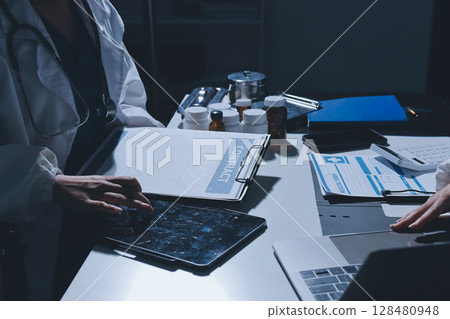 Male and female doctors are having a meeting in a hospital room. 128480948