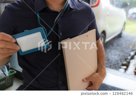 A person visiting a home wearing an ID card [The card is blank] 128482146
