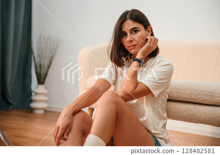On the floor. Beautiful woman in casual clothes is at home in domestic room On the floor. Beautiful woman in casual clothes is at home in domestic room 128482581