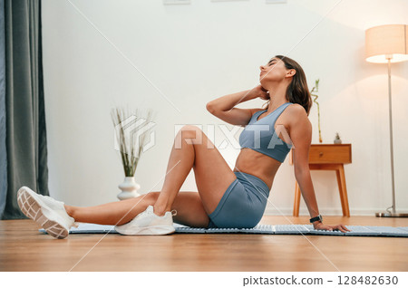Neck exercises. Pretty woman in sportive clothes have fitness day indoors 128482630