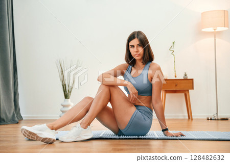 On yoga mat. Pretty woman in sportive clothes have fitness day indoors On yoga mat. Pretty woman in sportive clothes have fitness day indoors 128482632
