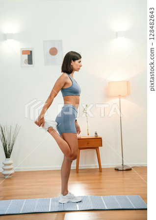 Warm up exercises. Pretty woman in sportive clothes have fitness day indoors 128482643