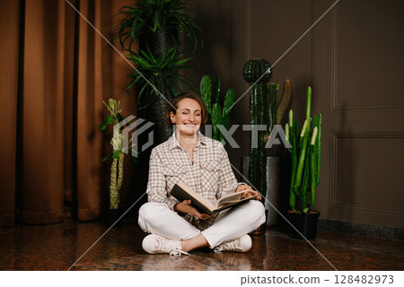 Woman Smiling While Reading A Book 128482973