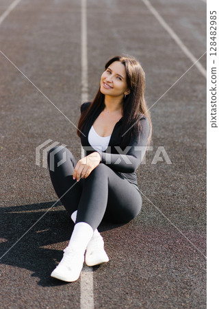 Relaxed Woman Sitting On Outdoor Track Relaxed Woman Sitting On Outdoor Track 128482985