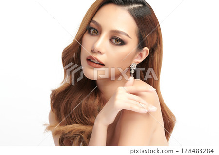 A beautiful young Asian woman with clean, fresh skin against a white background. Skincare, facial treatment, cosmetology, beauty, and spa. An elegant portrait of an Asian woman. 128483284