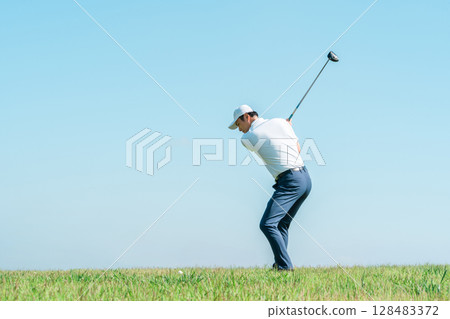 A golfer's man playing golf on a golf course (tee shot/golf competition) A golfer's man playing golf on a golf course (tee shot/golf competition) 128483372
