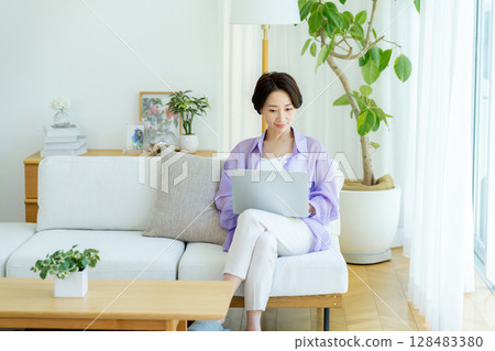 Middle-aged woman using a laptop in her room 128483380