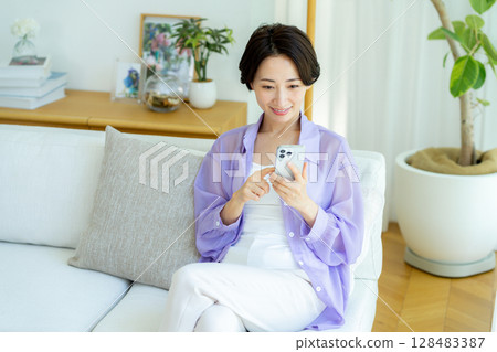 中年婦女在房間使用智慧型手機 128483387