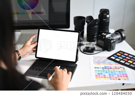 Photographer using digital tablet with blank screen at creative workstation Photographer using digital tablet with blank screen at creative workstation 128484030