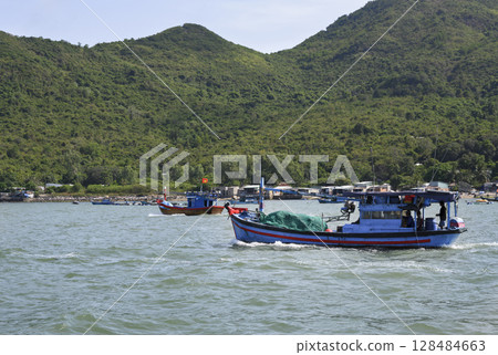 Fishing boats near a mountainous island in the South China Sea near Nha Trang, Vietnam 128484663