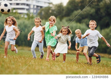 Kids are having fun on the field at daytime together Kids are having fun on the field at daytime together 128484866