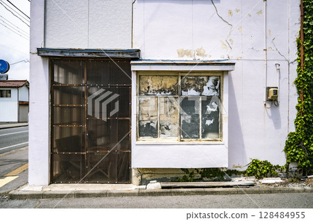 破裂的外牆和結霜的窗戶 | 老建築的外觀顯示出時間的流逝 破裂的外牆和結霜的窗戶 | 老建築的外觀顯示出時間的流逝 128484955