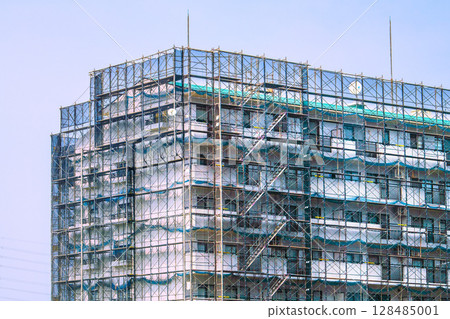 Yokohama cityscape in Japan. Apartment building repairs and inspections, scaffolding and protective nets. Satellite antennas outside the nets. Yokohama cityscape in Japan. Apartment building repairs and inspections, scaffolding and protective nets. Satellite antennas outside the nets. 128485001