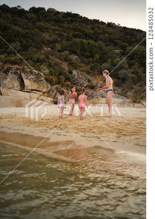 Family enjoying fun beach moments together on a sunny day 128485032