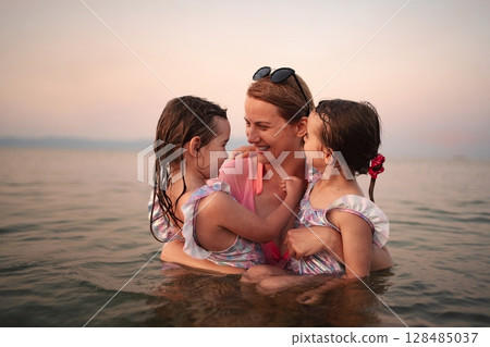 Joyful family bonding at the beach during sunset Joyful family bonding at the beach during sunset 128485037