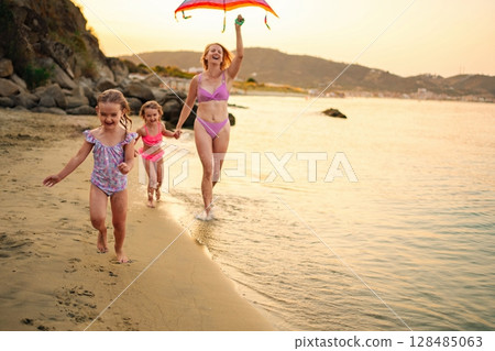 Family enjoys a sunny beach day with laughter and joy 128485063
