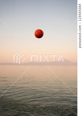 Family enjoys playful moments at the beach during sunset 128485084