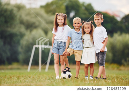 Positive and cheerful kids are having fun on the field at daytime together Positive and cheerful kids are having fun on the field at daytime together 128485209