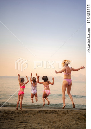 Joyful family moments at the beach during a sunny afternoon 128485235