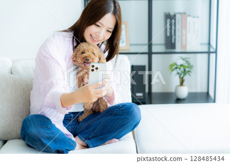 Young woman relaxing with her pet in her room 128485434