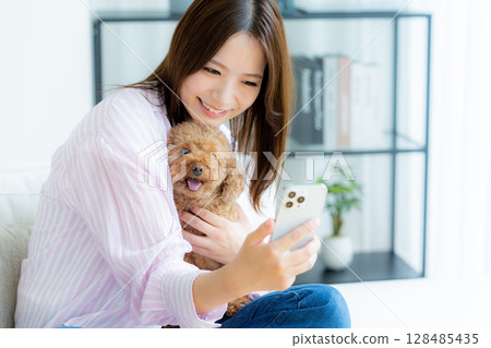 Young woman relaxing with her pet in her room 128485435