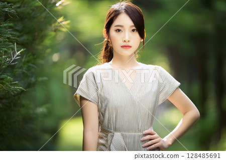 AI-generated image: Portrait of a young Japanese woman posing while standing amidst fresh greenery 128485691