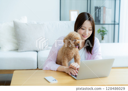 Young woman relaxing with her pet in her room 128486029