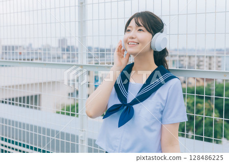 聽到在屋頂的音樂的高中女孩 128486225