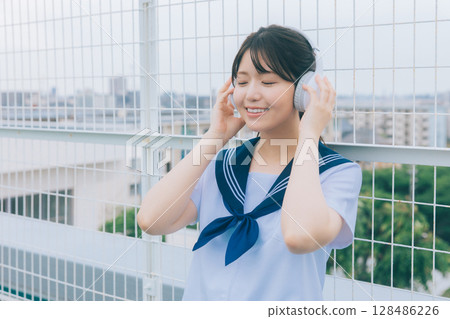 High school girl listening to music on the roof High school girl listening to music on the roof 128486226