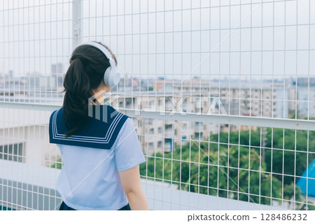 聽到在屋頂的音樂的高中女孩 128486232