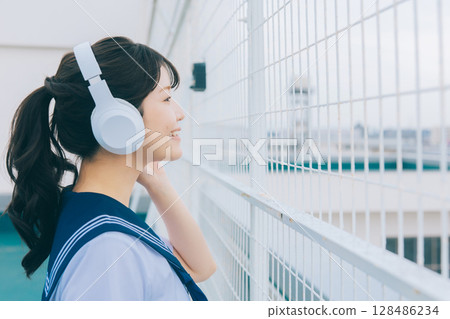 聽到在屋頂的音樂的高中女孩 128486234