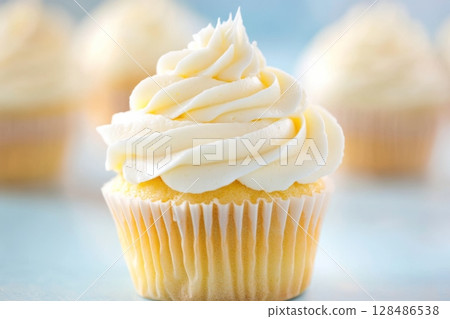 Vanilla Cupcakes topped with creamy sweet frosting treat. Tempting display of freshly baked cupcakes with white rich buttercream on top. Space for text. Close-up view. Seasonal celebrations. Birthday 128486538