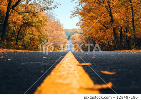 Autumn Forested Road with Yellow Marking Lines. Journey Through Beautiful Vivid Colors of Fall in Nature. Autumnal Asphalt road bright blue sky Country road in colorful autumn forest, orange trees 128487180