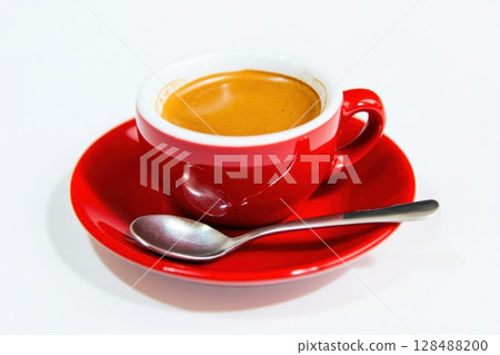 Red espresso cup filled of rich strong coffee. Freshly poured espresso mug, saucer, little spoon isolated on white. Soft shadow. Space for text. Tasty coffee with foam in cup. Aromatic morning drink Red espresso cup filled of rich strong coffee. Freshly poured espresso mug, saucer, little spoon isolated on white. Soft shadow. Space for text. Tasty coffee with foam in cup. Aromatic morning drink 128488200