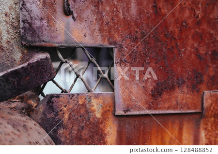 Old aged metal gate closed front view. Rusty doors with paint peeled out close up view. Closed private area. Abstract red brown metal sheet, panel. 128488852