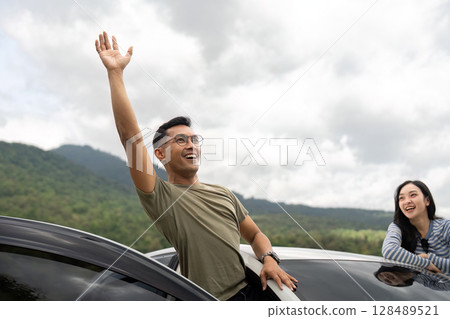 Joyful Road Trip Adventure. Friends waving from car windows in nature. Joyful Road Trip Adventure. Friends waving from car windows in nature. 128489521