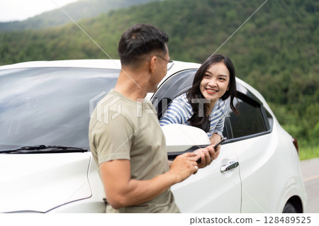 Casual Conversation. Young couple chatting by their car. 128489525