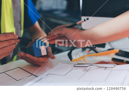 Closeup of team of industrial engineers meeting analyze machinery blueprints consult project on table in manufacturing factory. Working in manufacturing plant or production plant. Closeup of team of industrial engineers meeting analyze machinery blueprints consult project on table in manufacturing factory. Working in manufacturing plant or production plant. 128490756