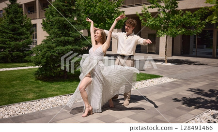 Elegant dance performance in summer garden with vibrant greenery Elegant dance performance in summer garden with vibrant greenery 128491466