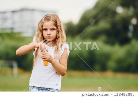 Little girl is playing with bubbles outdoors 128492093