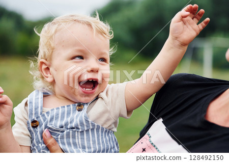 Cute and happy little boy is being holding by woman hands 128492150