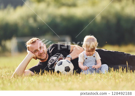 Father with his little son is on the field. With soccer ball Father with his little son is on the field. With soccer ball 128492188