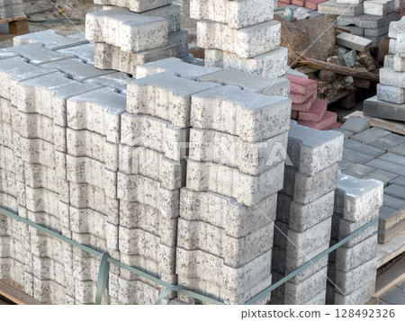 Several stacks of concrete blocks are arranged neatly at a construction site, ready for use in various building activities Several stacks of concrete blocks are arranged neatly at a construction site, ready for use in various building activities 128492326