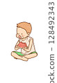A boy sitting cross-legged and eating watermelon 128492343