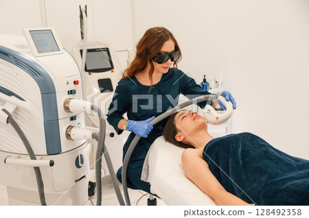 In protective eyewear. Getting photo rejuvenation procedure at cosmetology clinic 128492358
