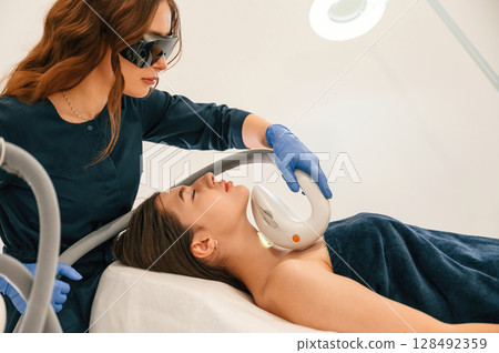 In protective eyewear. Getting photo rejuvenation procedure at cosmetology clinic 128492359