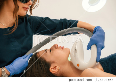 In protective eyewear. Getting photo rejuvenation procedure at cosmetology clinic 128492362
