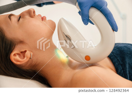 Woman is getting LPG hardware massage in beauty salon. Getting photo rejuvenation procedure at cosmetology clinic 128492364