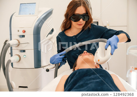 Lying down. Getting photo rejuvenation procedure at cosmetology clinic 128492368